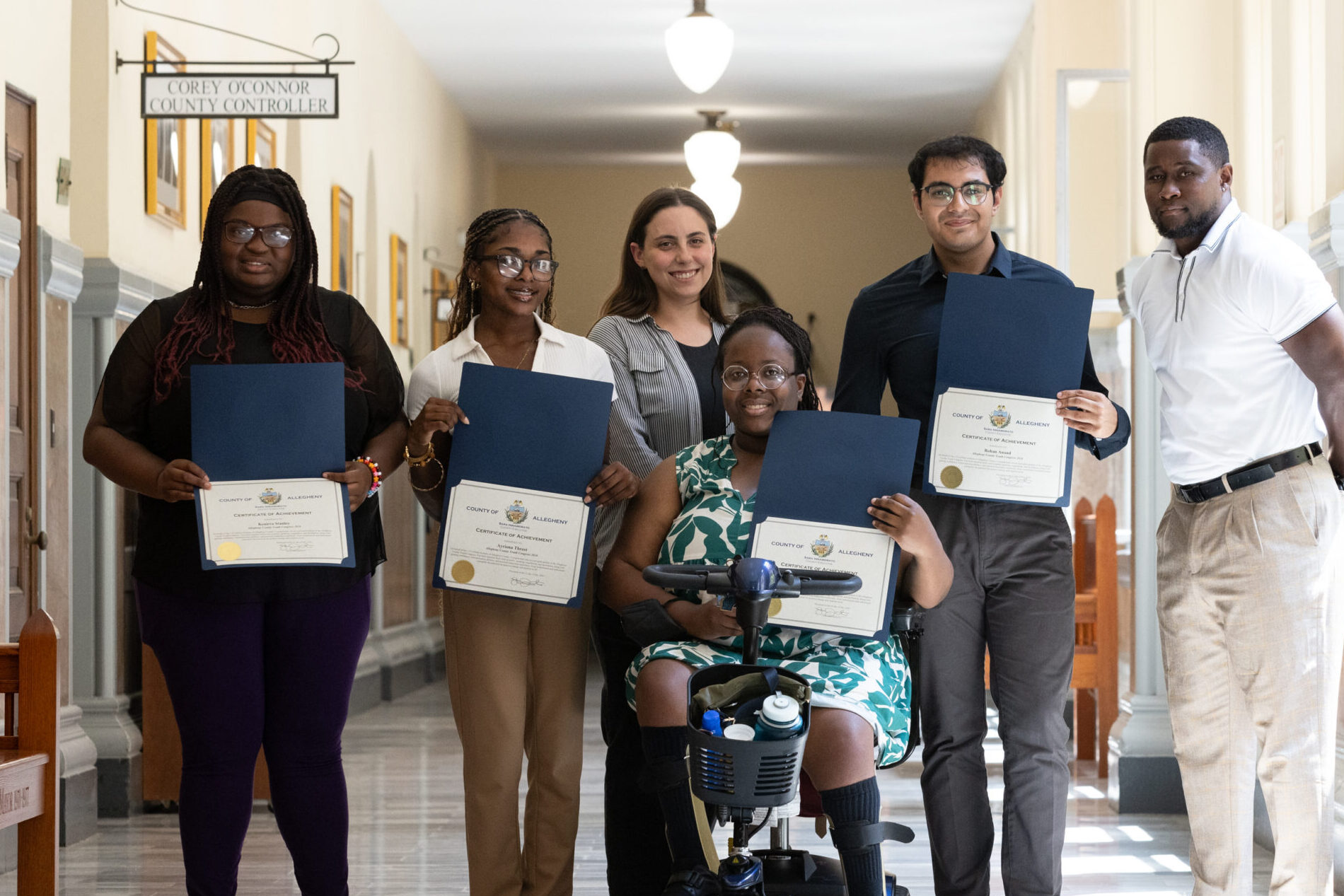 Diverse group of local youth stand in hallway of Allegheny County Courthouse holding certificates of completion for the first inaugural Youth Congress 
